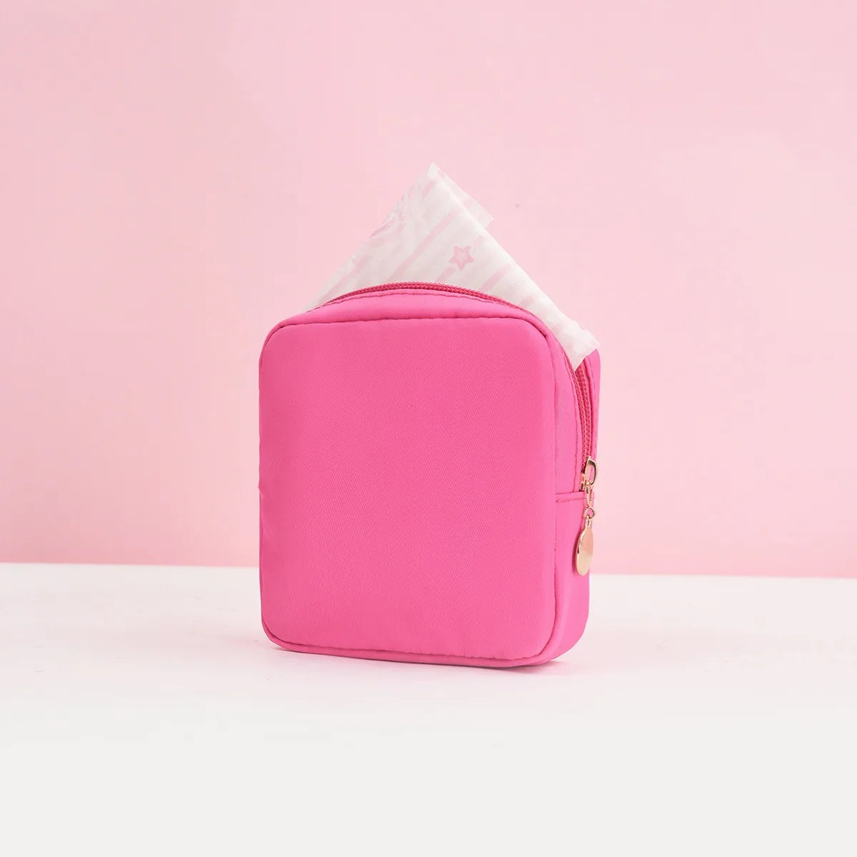 Helle pinke portable Tasche zum Aufbewahren von Tampons, mit einem weißen Taschentuch oben sichtbar.