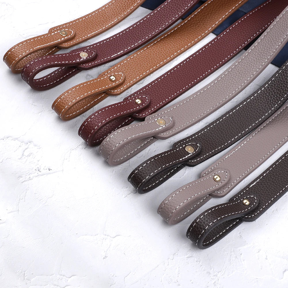 Collection de bretelles pour sac à main en cuir PU marron et beige disposées en diagonale.