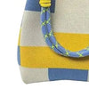 A geometric colorblock knitted bucket bag featuring yellow, blue, and white stripes with a blue drawstring.
