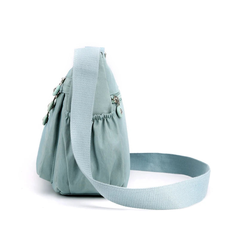 A light blue waterproof nylon crossbody shoulder bag with a matching strap is shown against a white background.