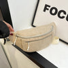 A beige corduroy crossbody waist bag with a silver zipper and adjustable strap is displayed against a white background.