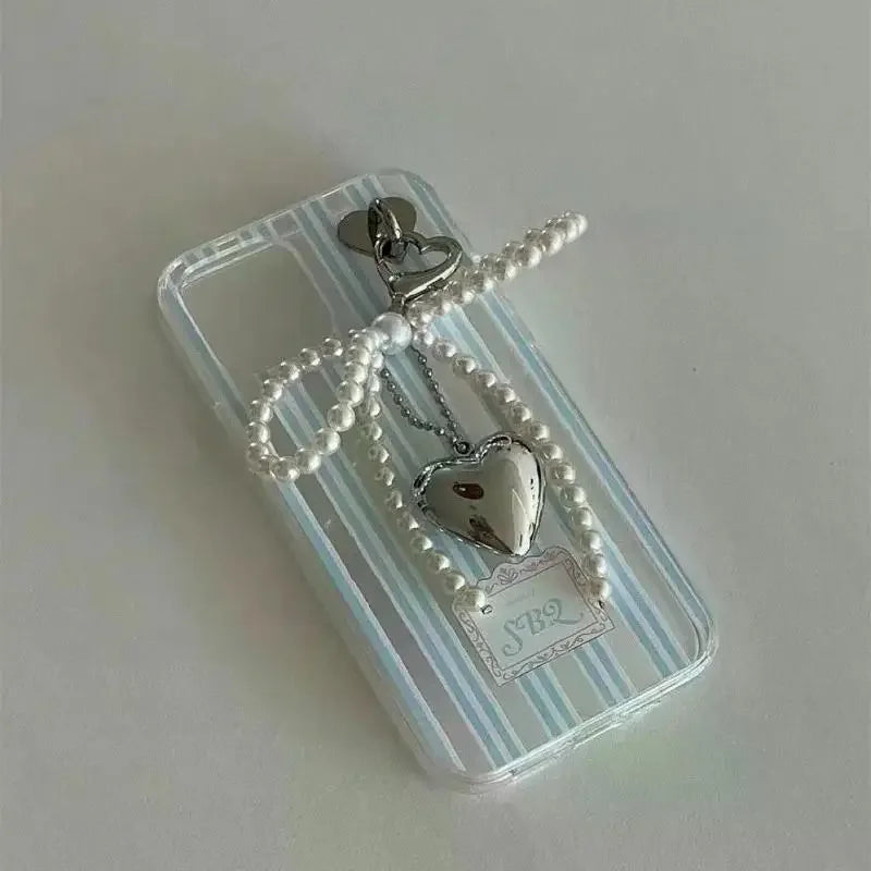 Silver heart charm necklace with pearls displayed on a clear plastic card.
