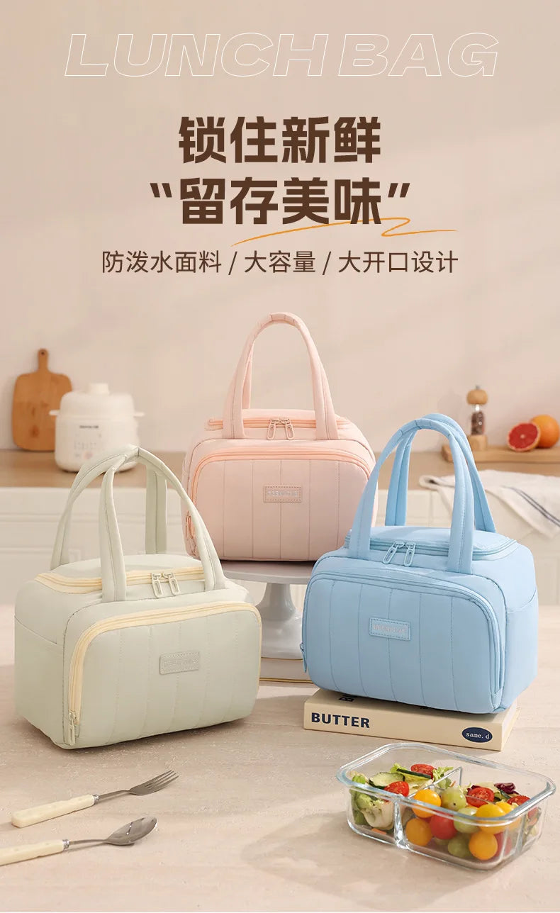 Una bolsa térmica acolchada rosa claro y azul se muestra en una mesa junto a un recipiente de fruta.