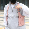 A person wearing a light gray jacket is holding a pink tactical chest bag with multiple pockets.