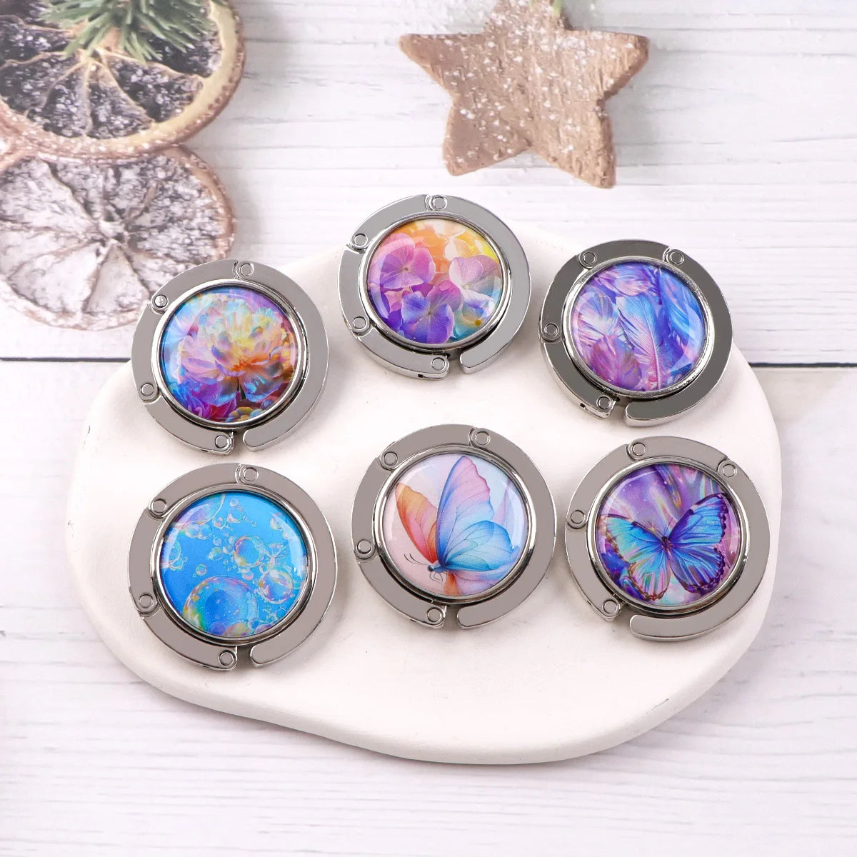 A set of five round metal hooks featuring colorful marble and starry sky designs on a white background.