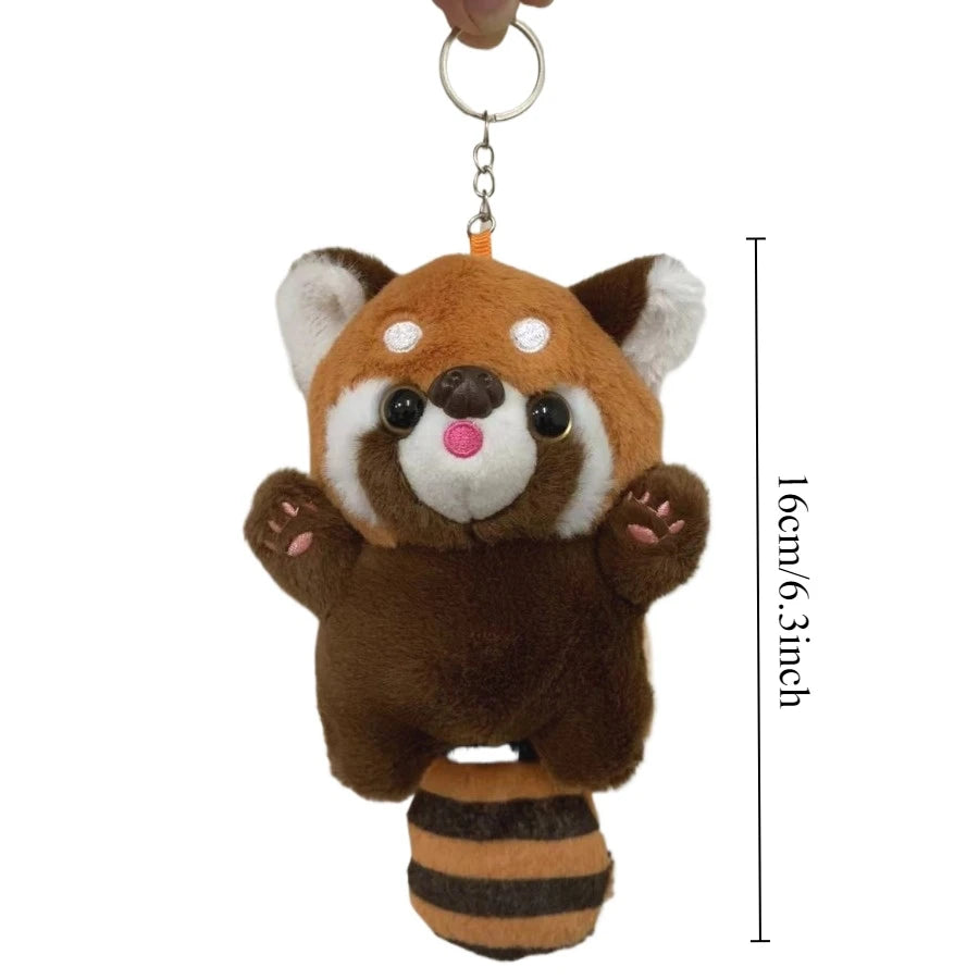 A brown and white red panda plush toy hanging from a metal ring.