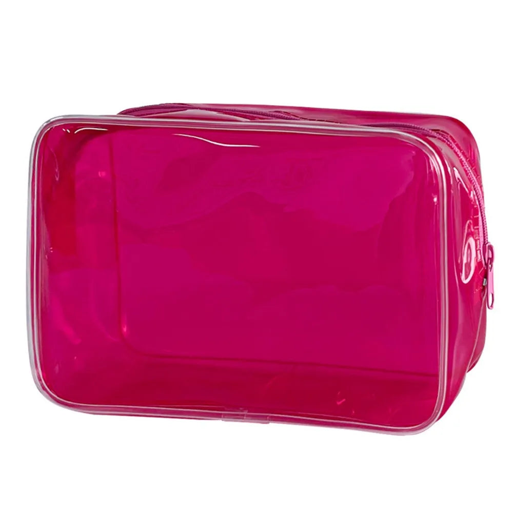 A glossy magenta transparent PVC travel makeup bag with a zipper closure.