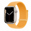 A silver Apple Watch is shown attached to a yellow braided stretch band.