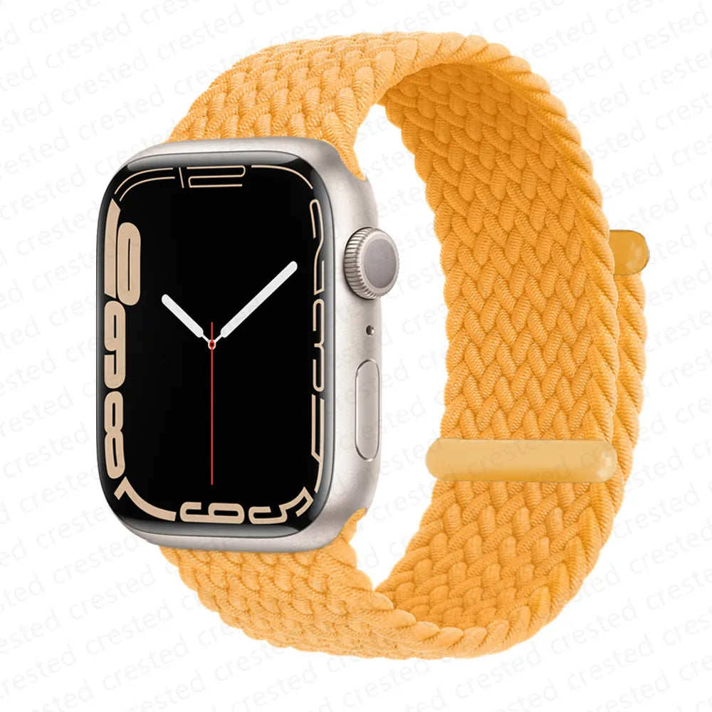A silver Apple Watch is shown attached to a yellow braided stretch band.