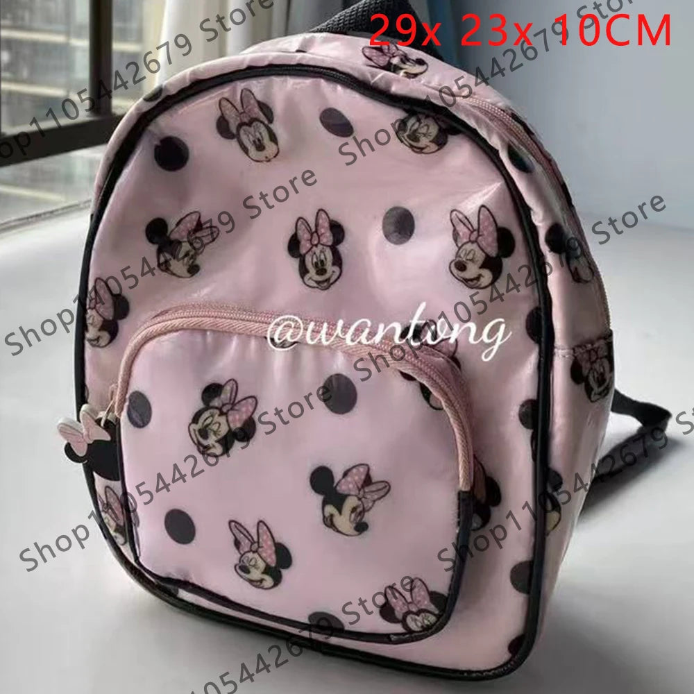Mochila de peluche rosa con forma de ratón pato y lunares negros, vista frontal.