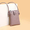 A light mauve compact PU leather crossbody bag with a zipper and strap resting on a white box.