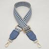 A braided nylon bag strap featuring a blue and beige checkered pattern with gold-toned metal hooks.