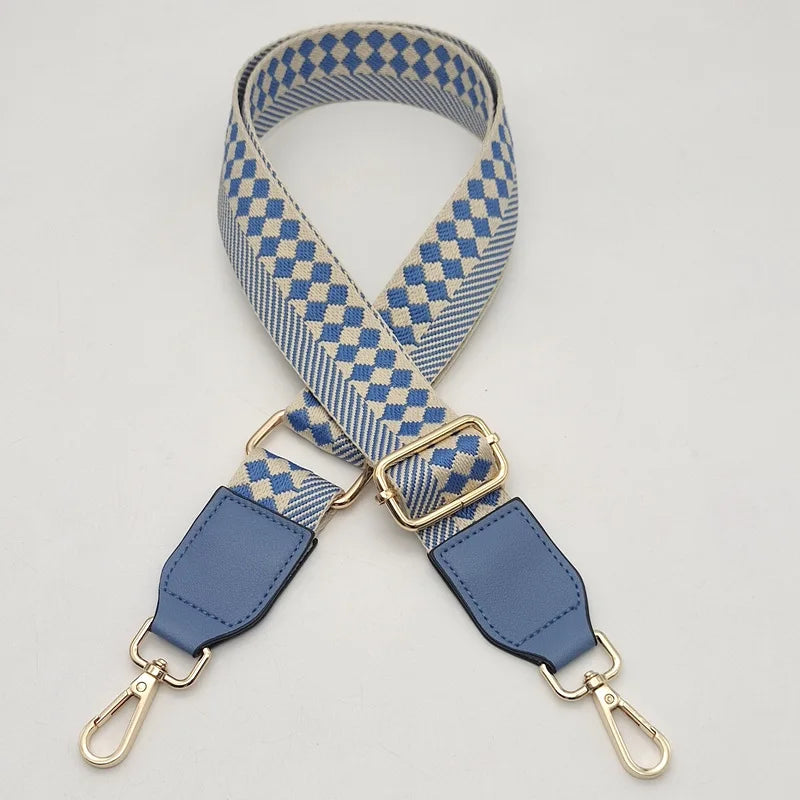 A braided nylon bag strap featuring a blue and beige checkered pattern with gold-toned metal hooks.