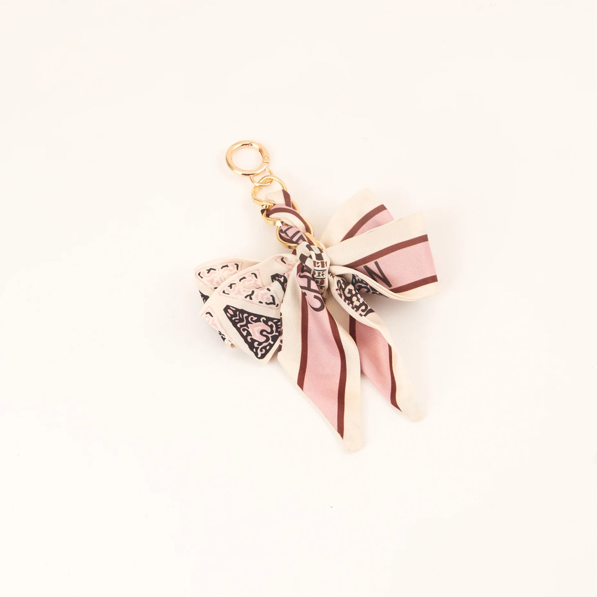 Llavero de lazo de seda a rayas beige y rosa con hebilla de metal dorada.