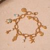 Gold charm bracelet featuring ocean pearl accents, starfish, and shell charms.