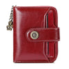 A deep red leather wallet with a brass clasp and card slots shown from the front.