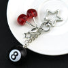 A silver Y2K 8 ball keychain charm featuring a red bead and a black ball on a white plate.