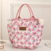 Bolsa térmica a cuadros rosa para almuerzo y pañales mostrada sobre una superficie blanca.