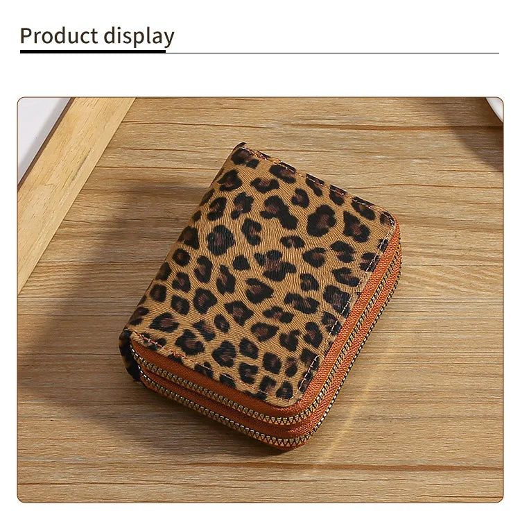 A brown leopard print double zipper wallet displayed on a wooden surface.