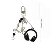 Silver music headphone keychain with black accents and a decorative bow.