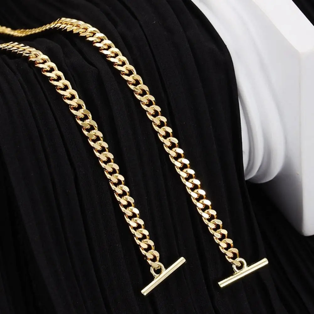 Gold chain strap for a handbag or crossbody bag displayed on black fabric.
