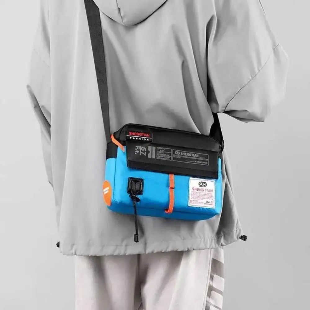 A gray hooded jacket with a blue waterproof nylon crossbody bag attached to the side.