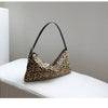 A brown leopard print vintage horsehair and cowhide crossbody bag resting on a white surface.