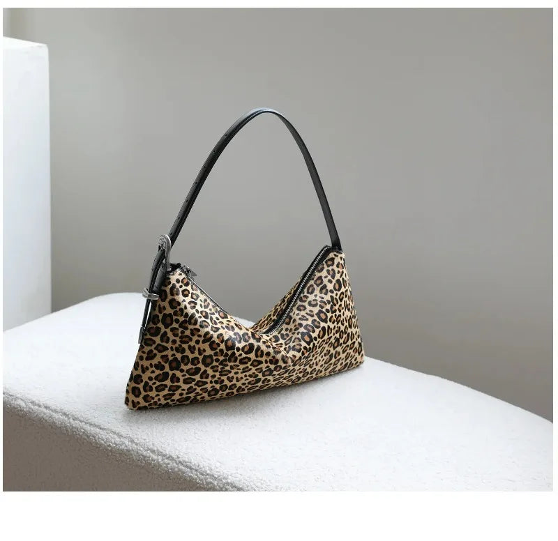 A brown leopard print vintage horsehair and cowhide crossbody bag resting on a white surface.