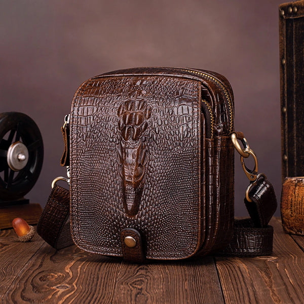 Sac bandoulière en cuir de vachette marron foncé pour homme posé sur une surface en bois.