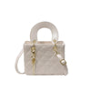 A light beige diamond grid textured crossbody bag with a curved handle and gold hardware.