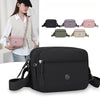 A black nylon crossbody bag is shown next to several color options and a woman wearing a light vest.