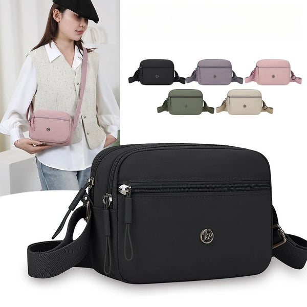 A black nylon crossbody bag is shown next to several color options and a woman wearing a light vest.