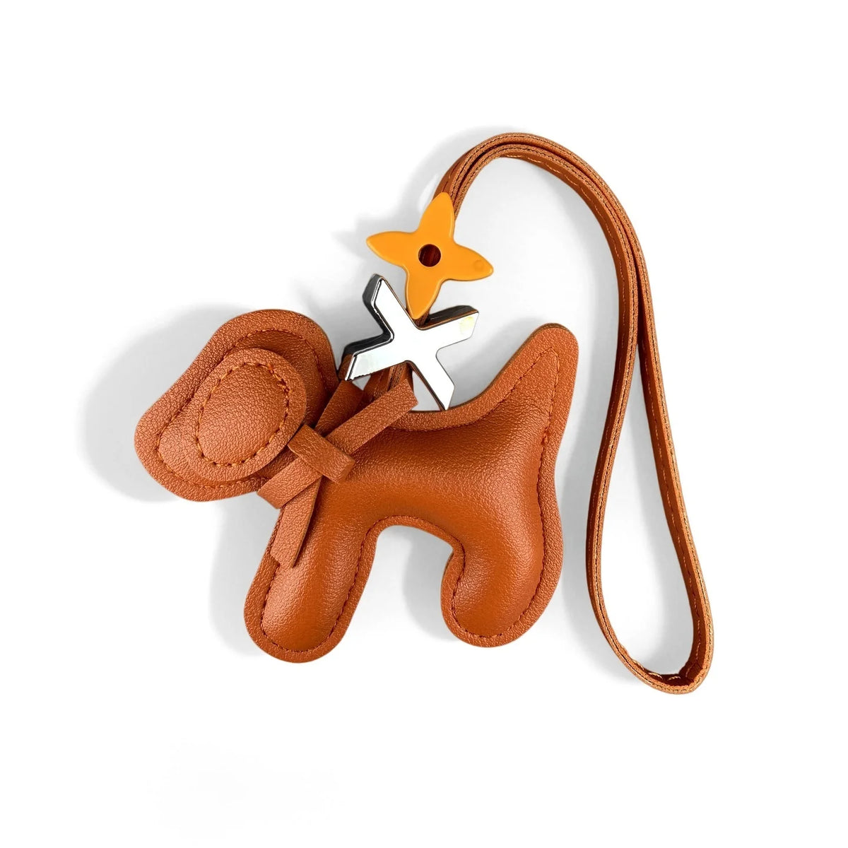 A brown PU leather puppy bag charm featuring a bow tie and a small orange flower, attached to a leather strap.