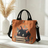 Orange blumiges Katzenmuster-Tasche mit schwarzem Riemen auf weißem Untergrund.