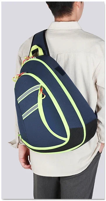 A person is wearing a navy blue medical crossbody bag with neon yellow accents over a light-colored shirt.