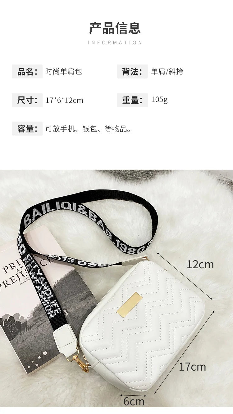Weiße gesteppte Leder-Crossbodytasche mit goldfarbenen Verzierungen vor weißem Plüschhintergrund.