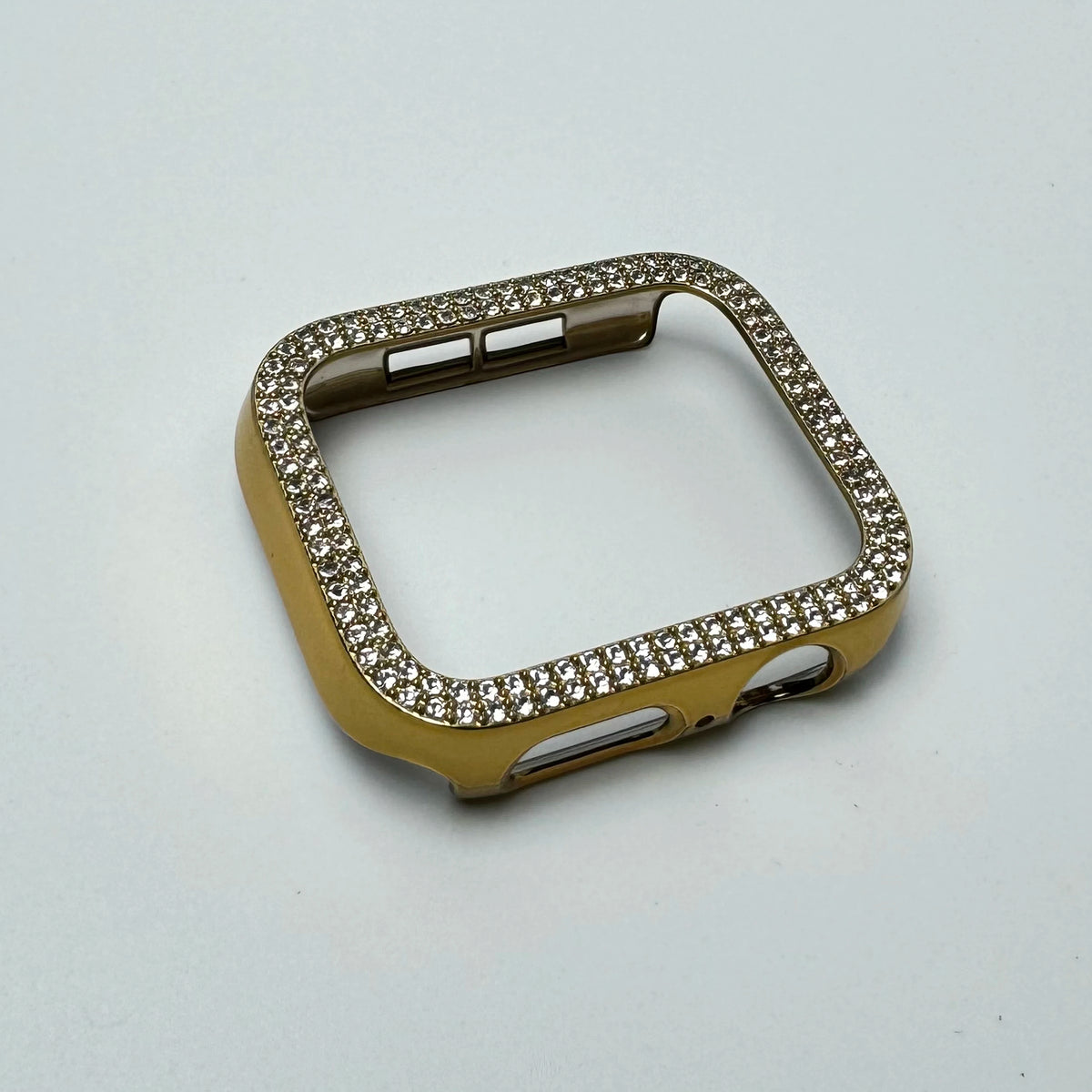 A gold-toned glitter diamond rhinestone bumper case for an Apple Watch, shown against a white background.