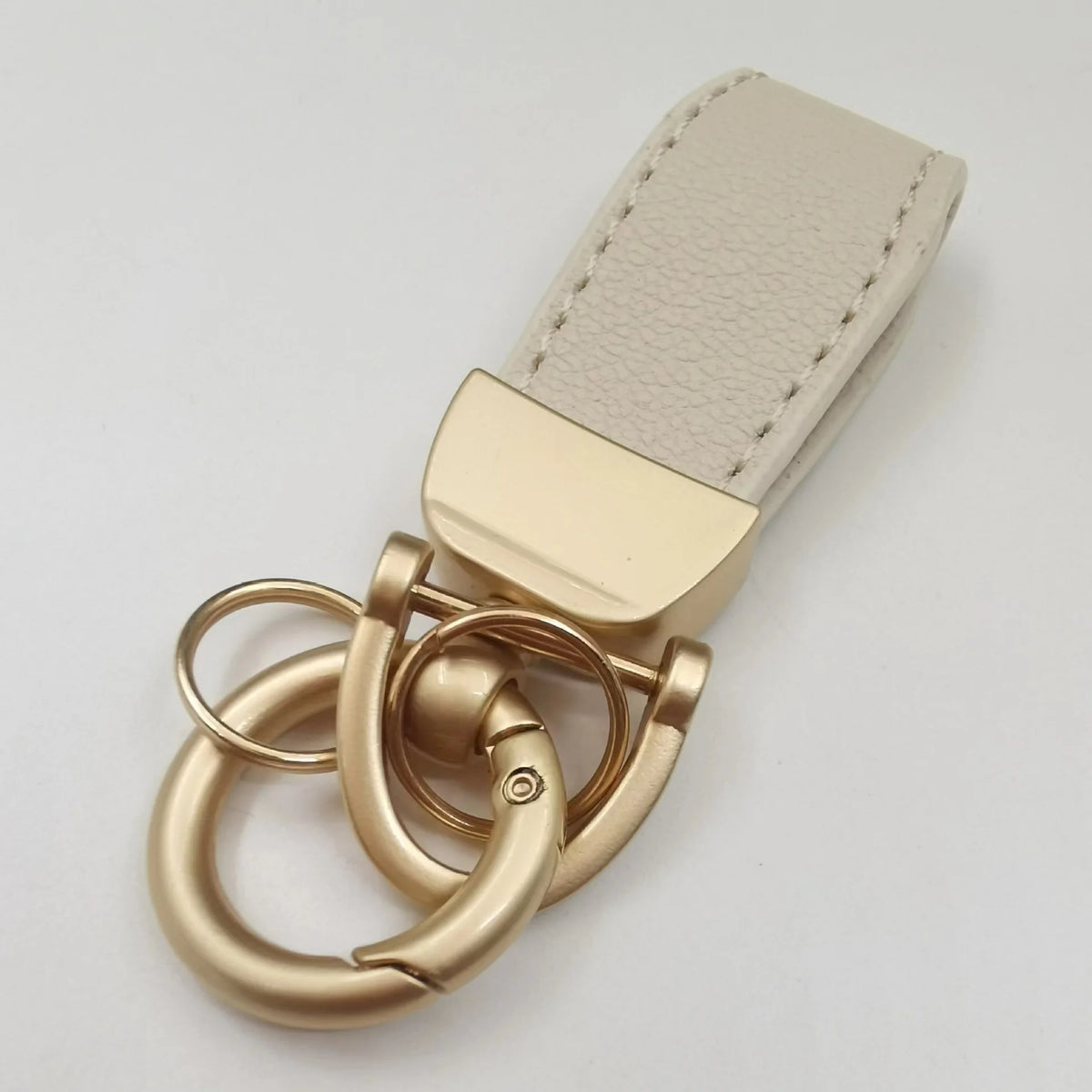 Beige Leder-Anhänger mit rechteckiger Karte und Messingverschluss.