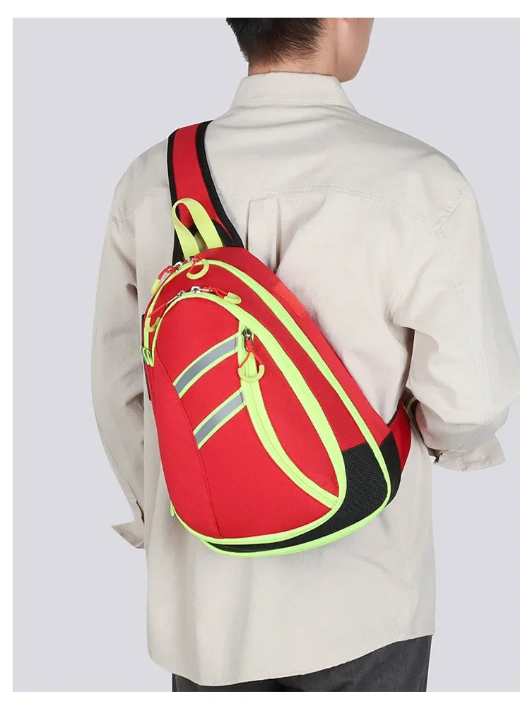 A red medical crossbody bag with yellow accents is worn on a person's back.