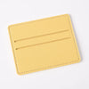 Porta tarjetas de cuero PU amarillo claro con dos ranuras horizontales.