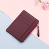 A dark purple PU leather card holder wallet with a zipper and keychain is shown on a light blue background.