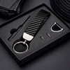 A black box holds a carbon fiber leather keychain with a silver finish and a small tool.