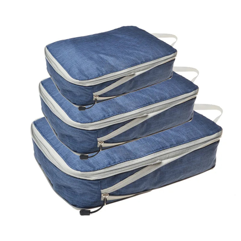A set of blue and gray reusable compression packing cubes stacked on a white background.