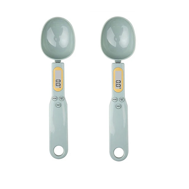 A pair of light gray precision digital kitchen scales with oval weighing bowls and measuring displays.