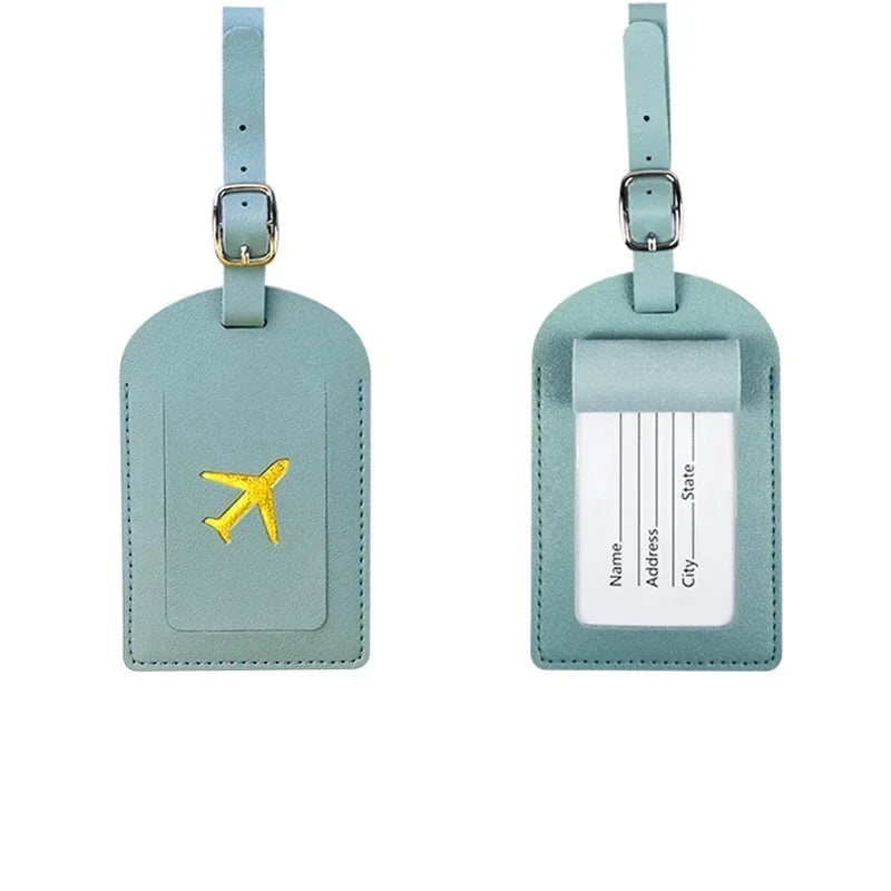 A pair of light mint green PU leather luggage tags with silver hardware and a yellow airplane emblem.