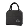 Black insulated lunch bag with a handle featuring a smiling bear design.