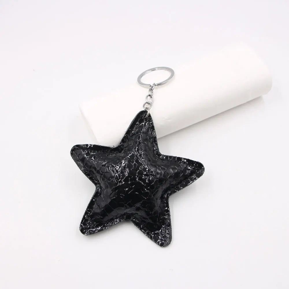 Black star shaped leather key chain bag pendant hanging from a silver keyring