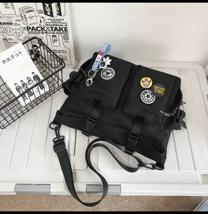 A black nylon crossbody bag with various charms and accessories is displayed next to a wire basket.