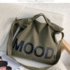 A dark olive canvas tote bag featuring the word MOOD printed in large, dark lettering.