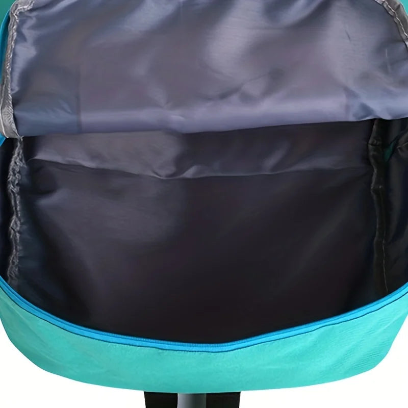 A close-up view of a purple and teal robot backpack with a dark gray fabric lining.